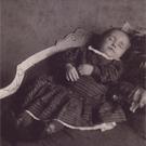 An infant laid out on a sofa